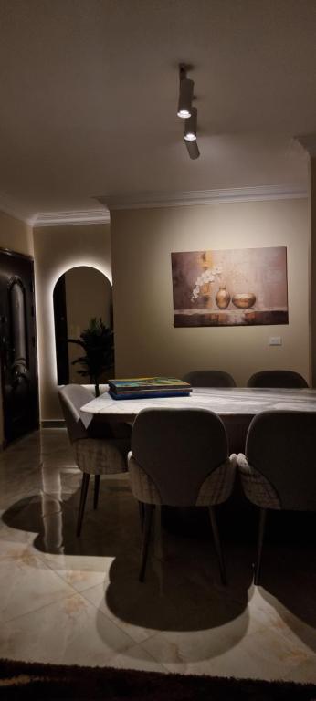 a living room with a table and some chairs at Tara Home 204 in Sheikh Zayed