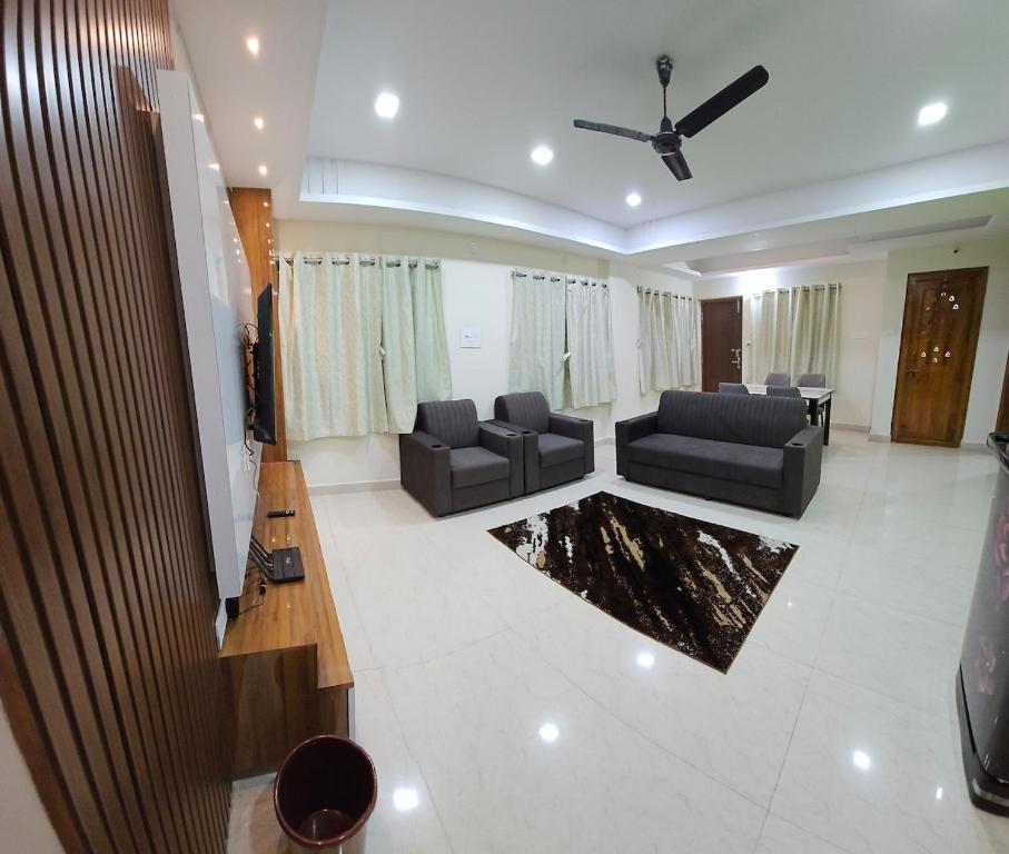 a living room with two couches and a ceiling fan at Hill View Haven in Rushikonda
