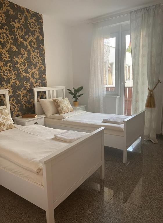 a bedroom with two beds and a window at City Comfort Hannover in Hannover