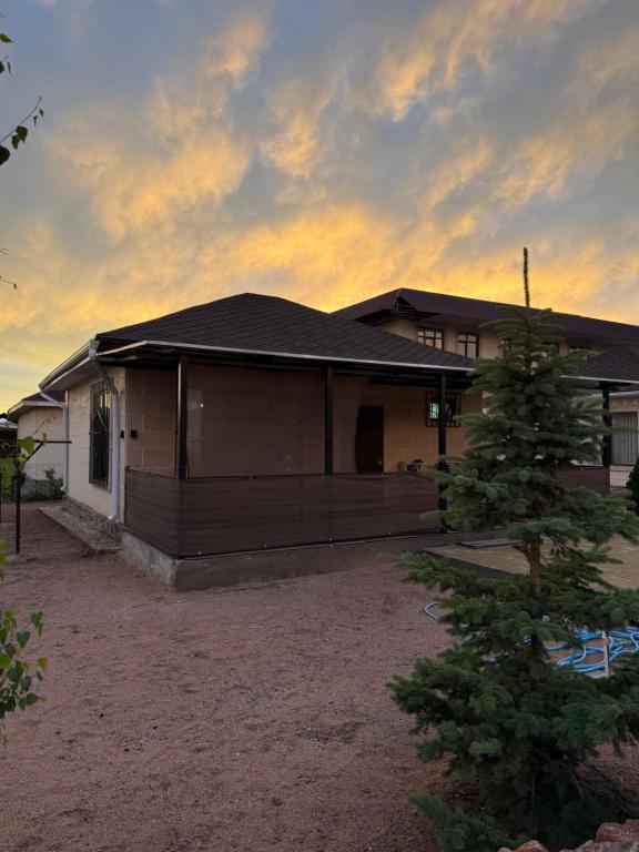a house with a tree in front of it at Diamond Resort Cottage Issyk-Kul in Bosteri