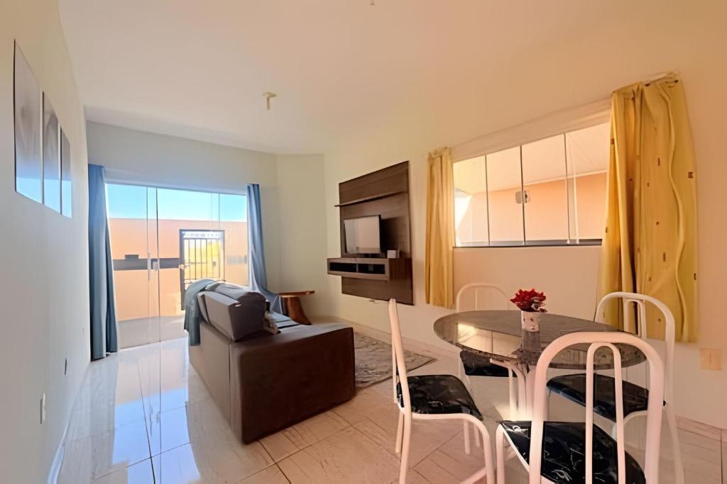 a kitchen and living room with a table and chairs at Completa e próxima ao Acqualinda in Andradina
