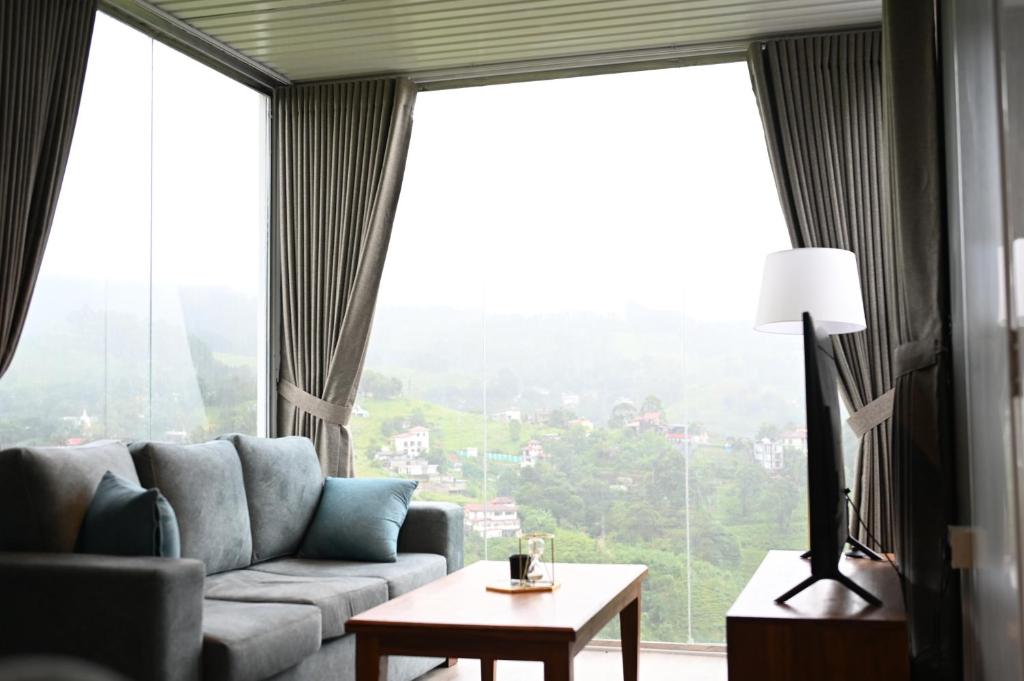 a living room with a couch and a large window at RuKu Villa Pussellawa in Pussellawa