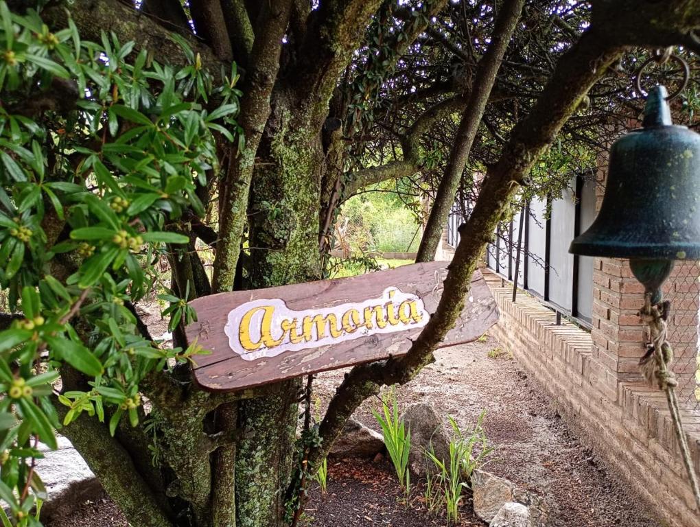 a sign on the side of a building with a bell at Chalet ARMONIA in La Falda