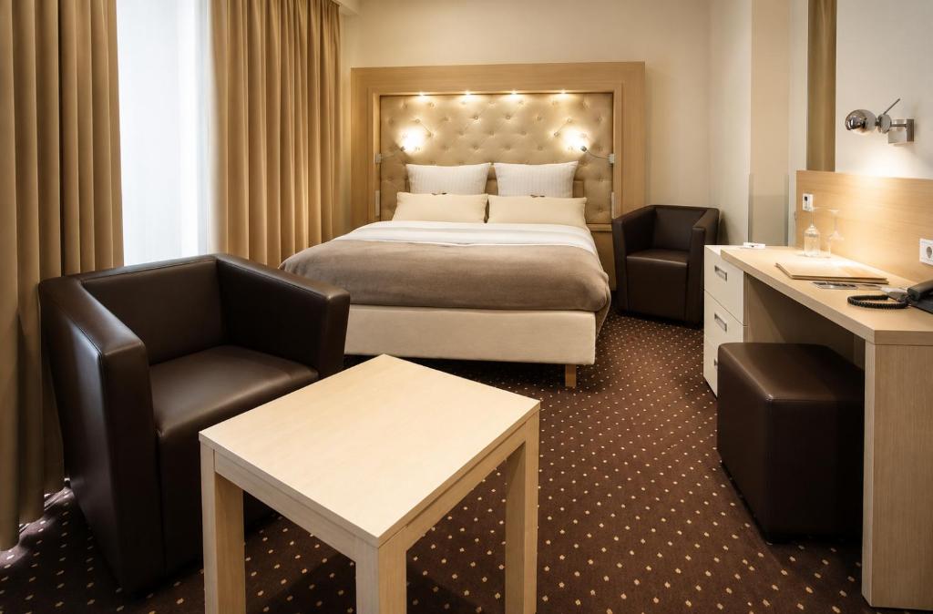 a hotel room with a bed and a desk and chair at Hotel Villa Will in Hannover