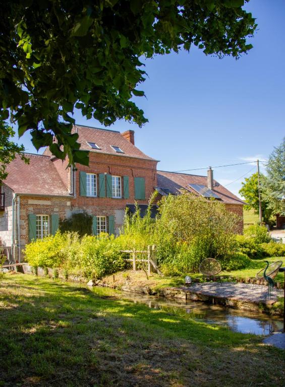 an old house with a river in front of it at Le Moulin de l`Epinay in Sainte-Beuve-en-Rivière