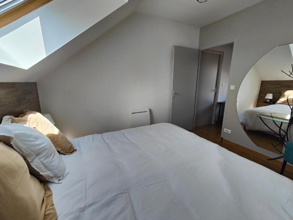a bedroom with a large white bed and a window at La Clé des Vignes 3 in Roye