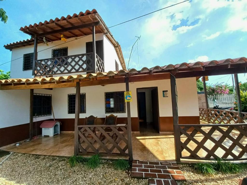a house with a balcony in front of it at Cabaña Bamel in San Antero