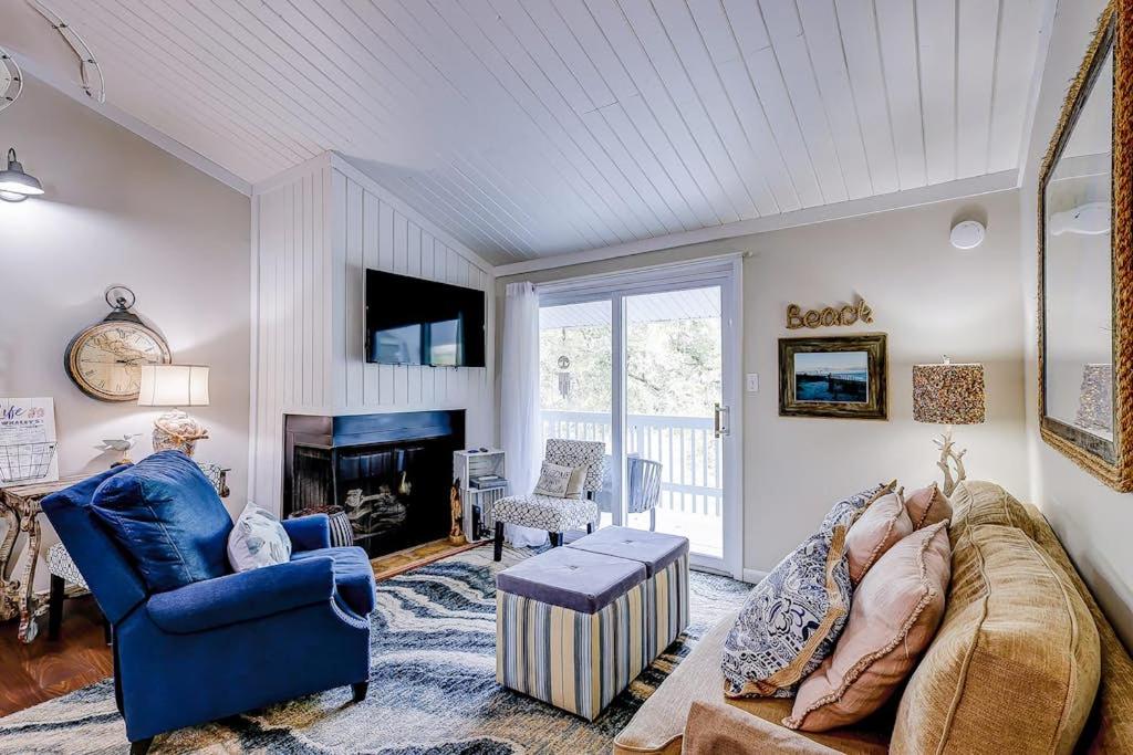 a living room with a couch and a fireplace at Driftwood Villa - 269 in Edisto Island