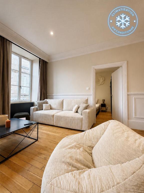 a living room with a couch and a table at La Suite Haussman in Guéret