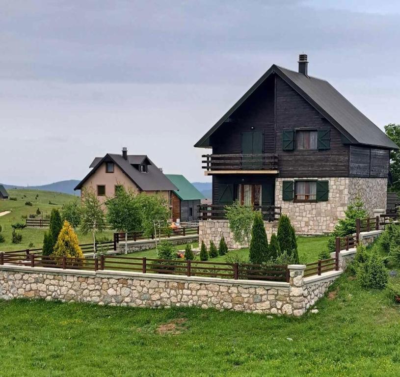a home with a stone retaining wall and a house at Wolf Chalet in Motički Gaj