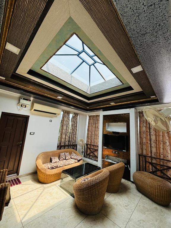a living room with a skylight and a table and chairs at Villa Clasic Comfort in Navalur