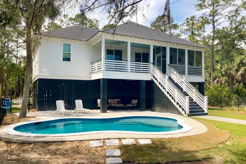 a house with a swimming pool in front of it at Nature's Touch in Edisto Island