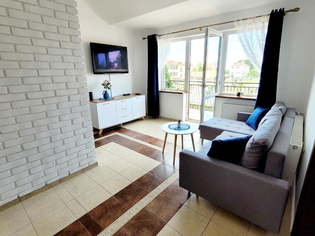a living room with a couch and a tv at Apartament Nad Lodziarnią in Wydminy