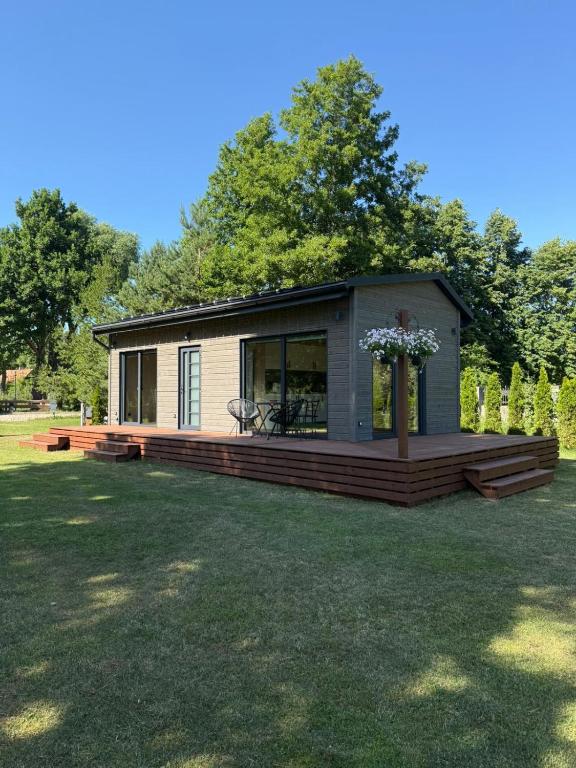 a small cabin in a yard with a deck at Jaunmāriņi in Liepāja