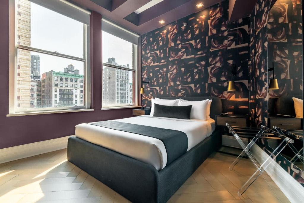 a bedroom with a bed and a large window at Flatiron Studio Near Madison Square Park in New York