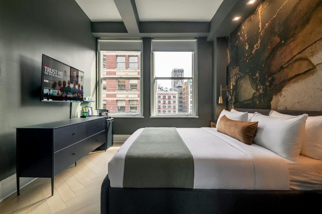 a bedroom with a large bed and a television at NoMad Studio Near Broadway & Madison Square in New York