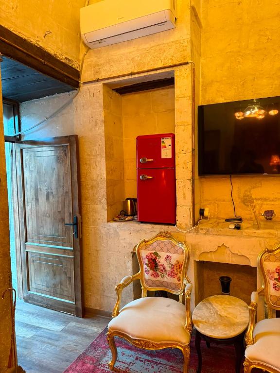 a room with a red refrigerator and two chairs at antik senyora butik in Urfa