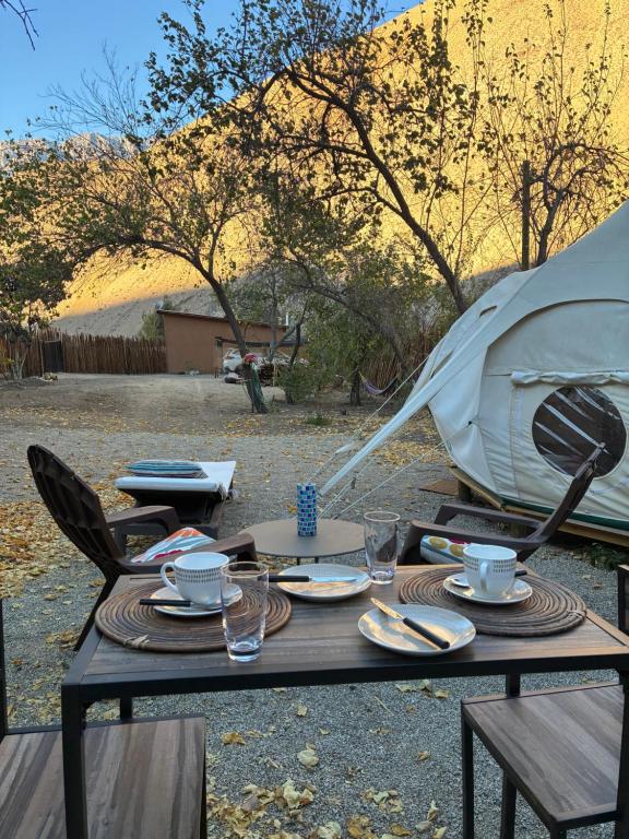 a table with plates and cups and a tent at Glamping Ramas De Elqui in Pisco Elqui