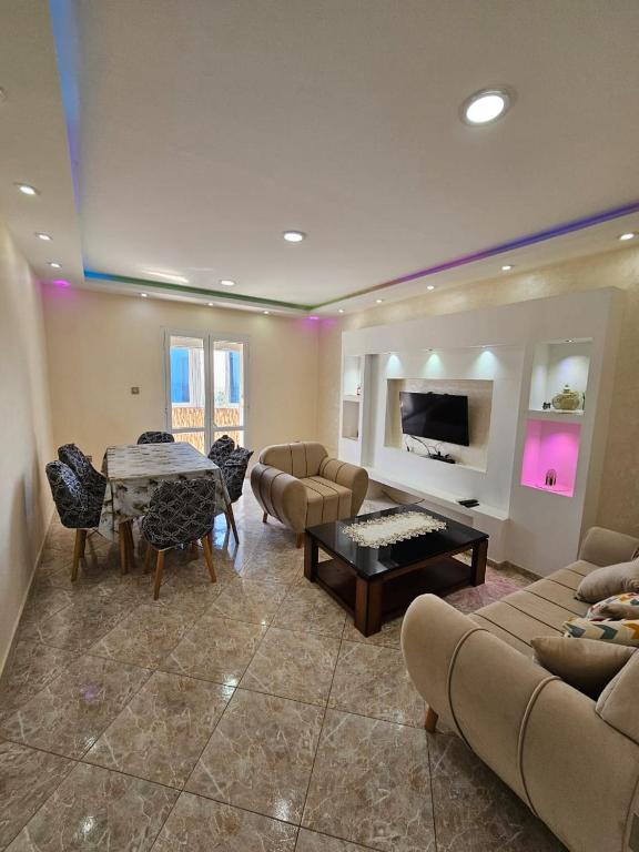 a living room with a couch and a table and chairs at Appartement Birkhadem in Birkhadem