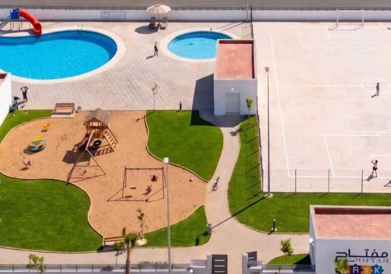 an aerial view of a park with two swimming pools at Super Appartement Sidi Rhal in Dar Hamida