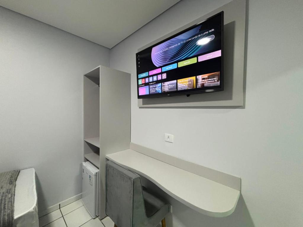 a bathroom with a sink and a tv on the wall at Hotel Colonial Plaza - Ao Lado do Metrô Armênia, 5 Min do Brás e Rua 25 de Março e 10 Min do Expo Pavilhões Anhembi in São Paulo