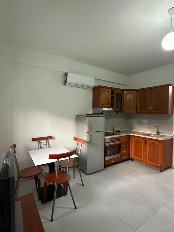 a kitchen with wooden cabinets and a table with chairs at Ikon Apartments in Kashari