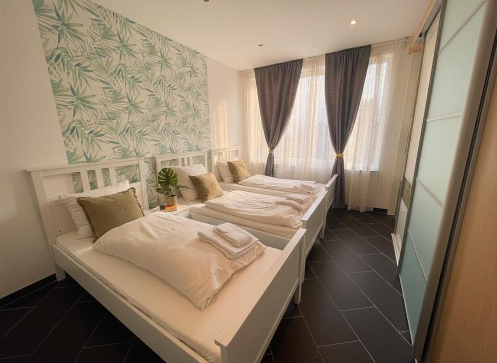 two beds in a small room with a mirror at Hannover Central Apartment in Hannover
