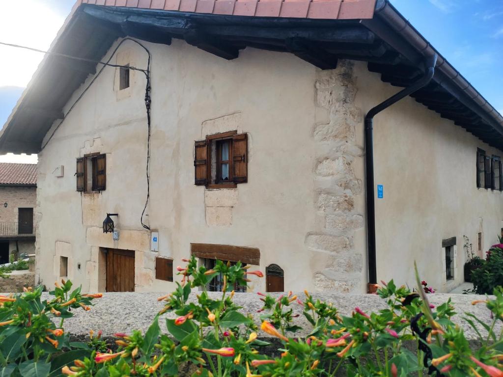 an old white building with windows and flowers at Etxezarra in Sáseta