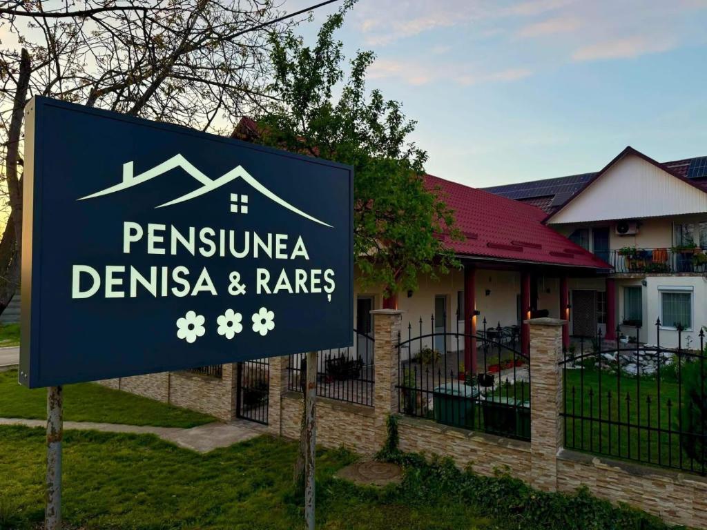 a sign in front of a house with a house at Denisa & Rares in Tăşnad