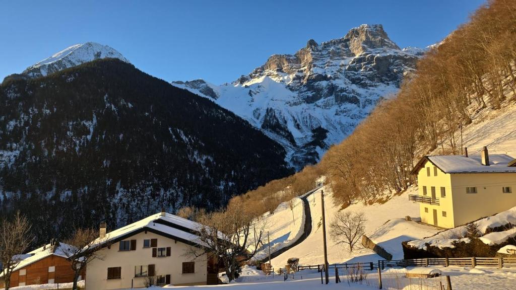 a village in the mountains with a snow covered mountain at Le Repos du Jorat in Saint-Maurice