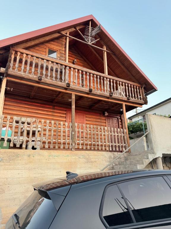 a car parked in front of a wooden house at Vikendica za odmor in Dobra Voda