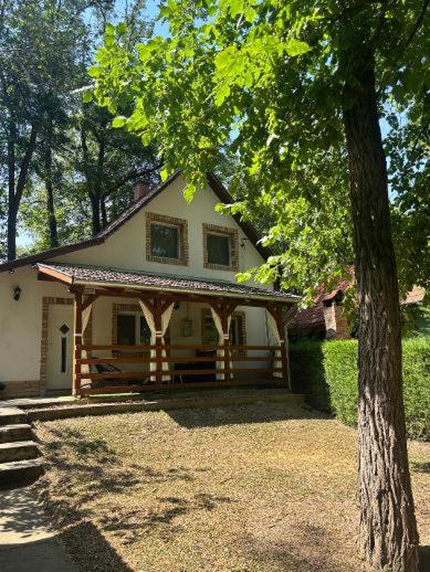 a small house with a porch and a tree at Tommy's Cottage in Harta