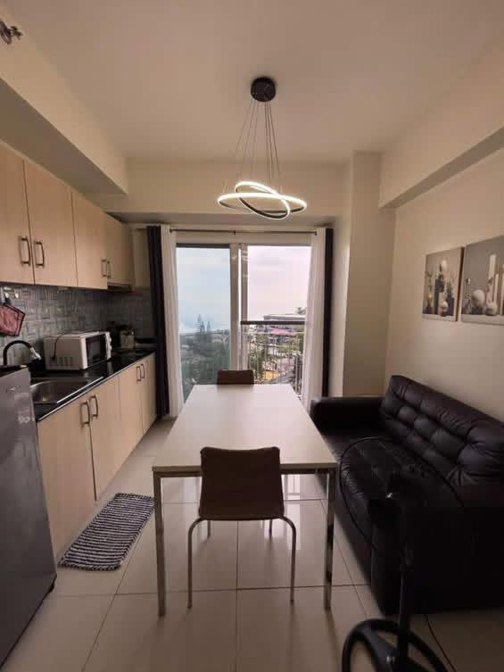 a kitchen and living room with a table and a couch at Casa Lumière in Tagaytay