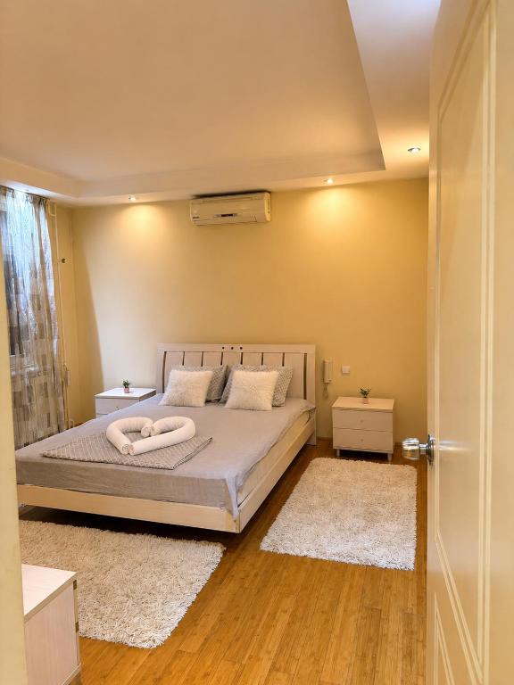 a bedroom with a bed with white blankets and pillows at Sunset Apartman Obrenovac,Centar in Obrenovac