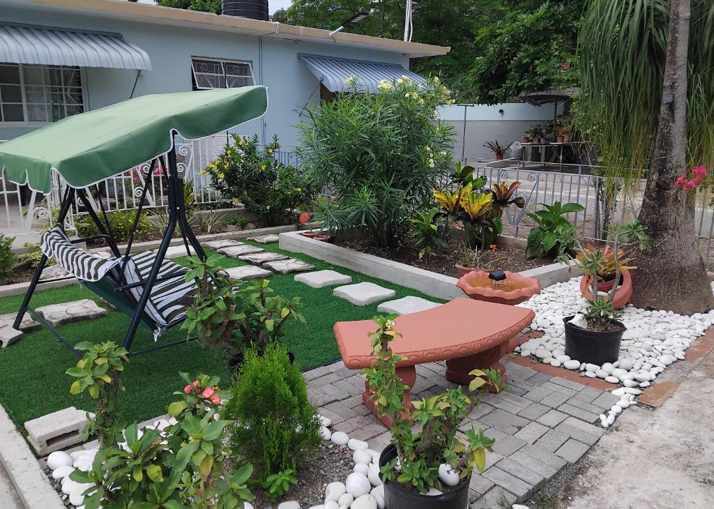 a garden with a table and a bench and plants at Haven Garden Retreat in Kingston