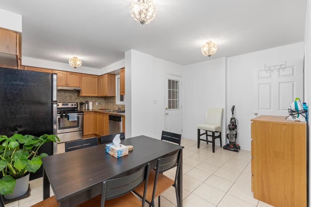 a kitchen with a table and a black refrigerator at Semi-Private Townhouse - 3 Bedrooms, 4 beds, Free Parking, Wifi, Netflix, - Hosted by Matthew in Toronto