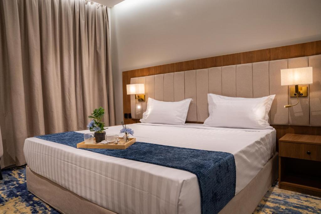 a bedroom with a large bed with a blue blanket at H SAM Hotel in Taif