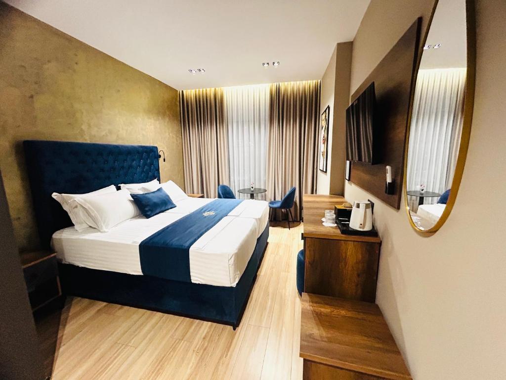 a hotel room with a bed and a mirror at Hotel Shopi Residence in Elbasan