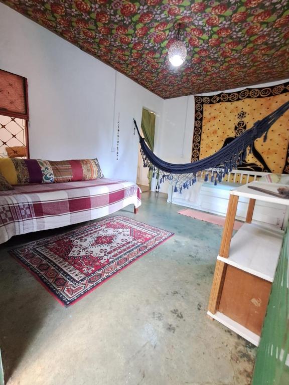 a room with a bed and a table and a rug at Vila Chapada Alta - Chapada dos Veadeiros in Alto Paraíso de Goiás