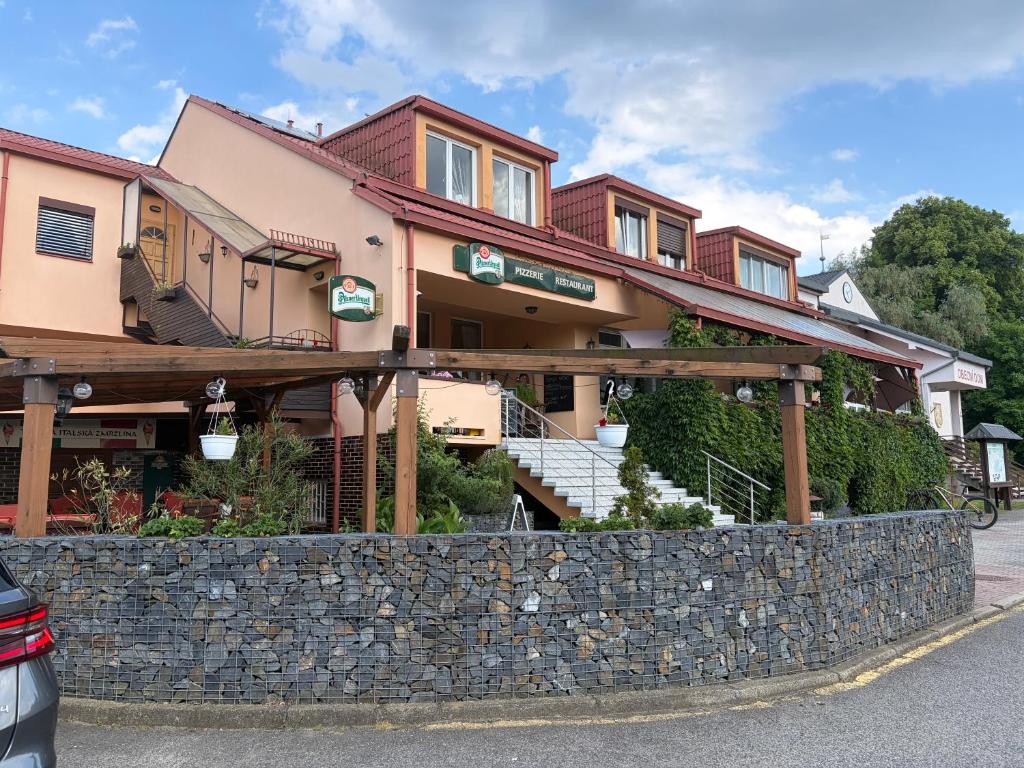 a building with a stone wall in front of it at Pizzerie Osičko in Bystřice pod Hostýnem