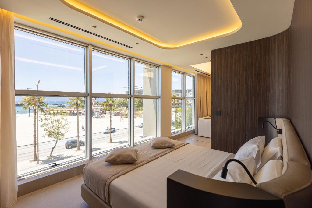 a bedroom with a large bed and a large window at Quartz Hotel Vlore in Vlorë