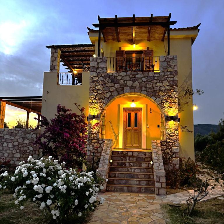 a house with a staircase leading up to the front door at "Villa Othon-Leni" - Panoramic Sea View & Traditional Luxury in Paralia Demonias