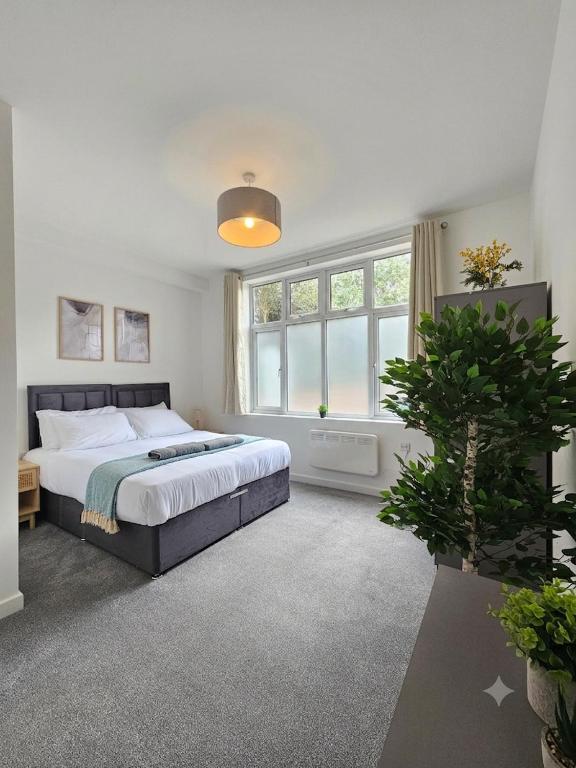 a bedroom with a bed and a large window at Luxury Flat 10 mins from Station with BIKE ! in Cambridge