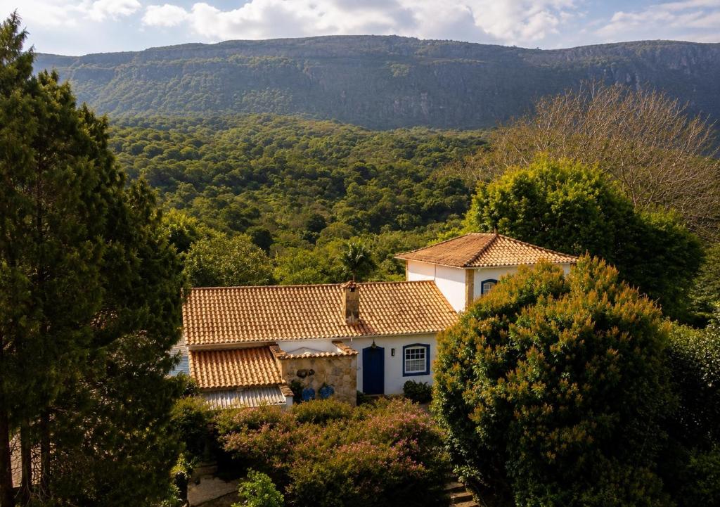 a house in the middle of a valley with trees at Segredo da Serra Pousada Boutique in Tiradentes
