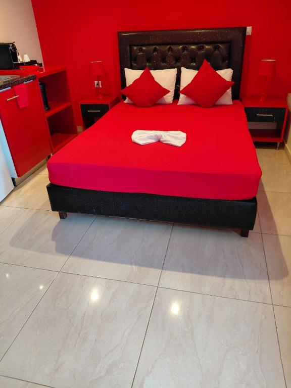 a bedroom with a red bed with a bow tie on it at Apartments Vesna Luxury & Michel ap 8 in Paralia Katerinis