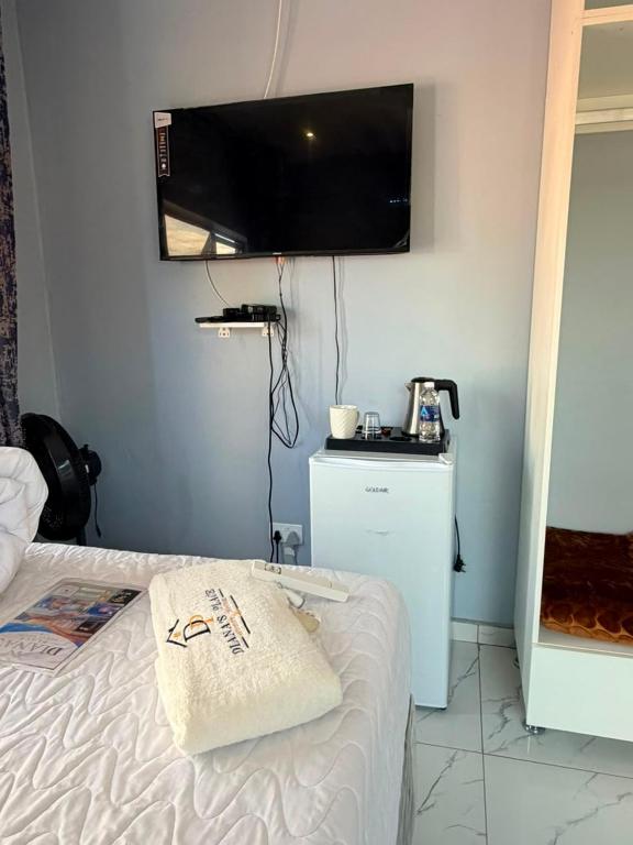 a bedroom with a bed and a flat screen tv at Diana's Place Guest house in Nyanda