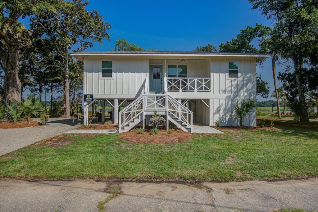 a large white house with a staircase in front of it at The Toasted Oyster in Edisto Island