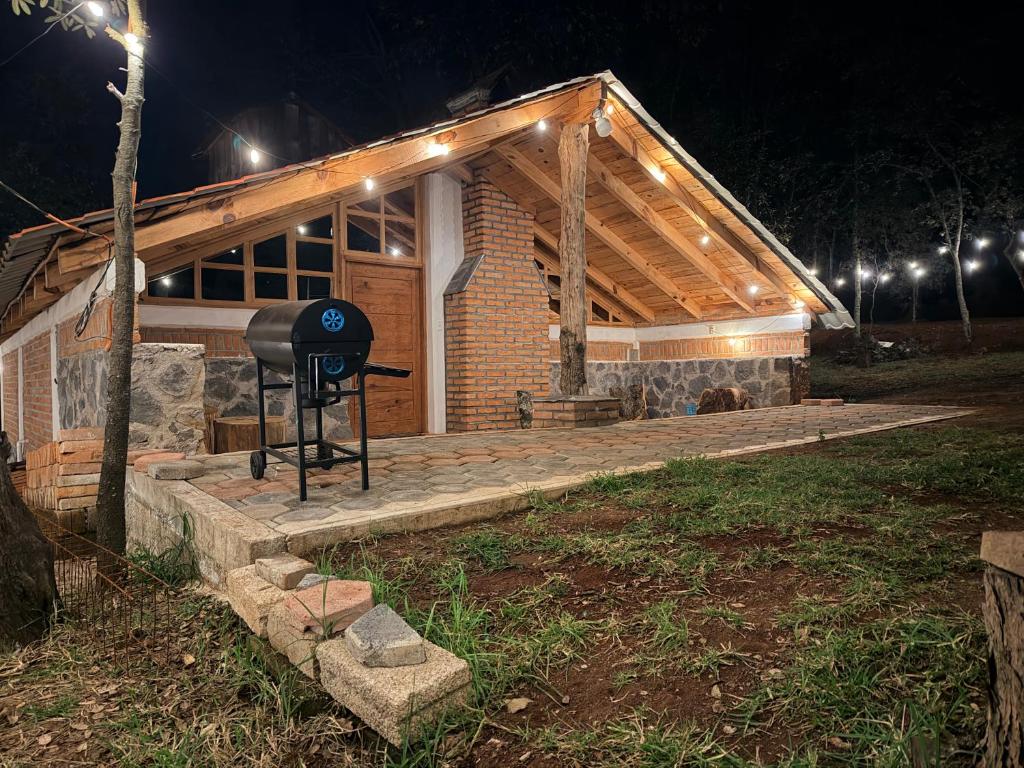 a house with a grill on a deck at night at Cabaña La Joyita By GEstores in Huasca de Ocampo