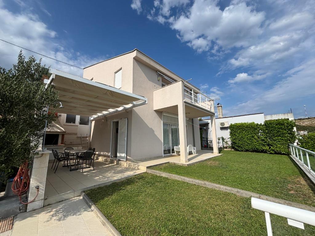 a white house with a patio and a yard at Villa Pontem in Komarna