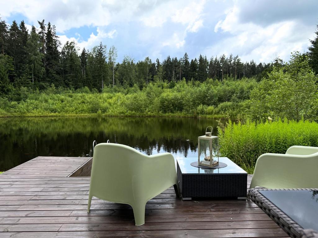 ein Tisch und Stühle auf einem Steg neben einem See in der Unterkunft SikaSpot Green in Sika